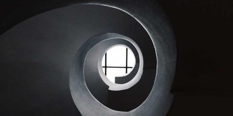 一辆老旧的汽车，车身上布满了岁月的痕迹，车轮已经生锈，但车头的车标依然清晰，仿佛在诉说着它的辉煌过往。