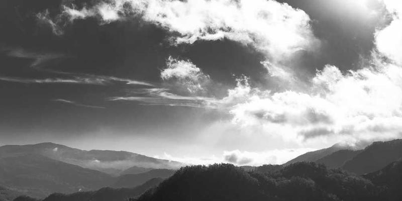 一位女性在深呼吸的同时,轻触她脖子上的项链,表情平静而自信